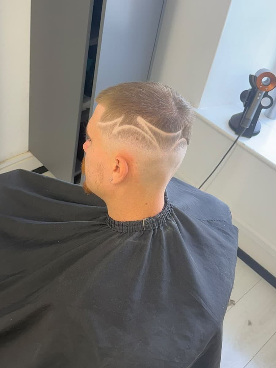 Skin fade with a freehand line design cut into the side, by Bucks
